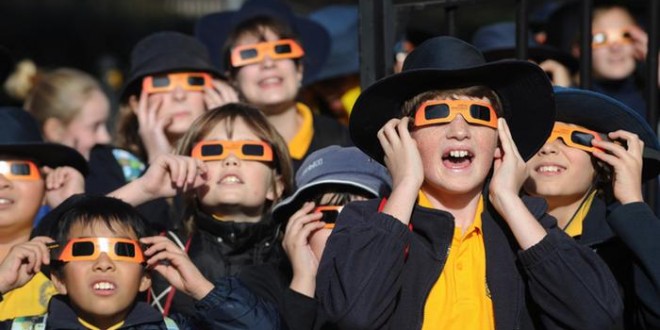 crianças observam eclipse